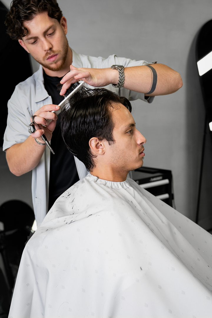 Barber in the Cool Gray Barber Jacket cutting a client&