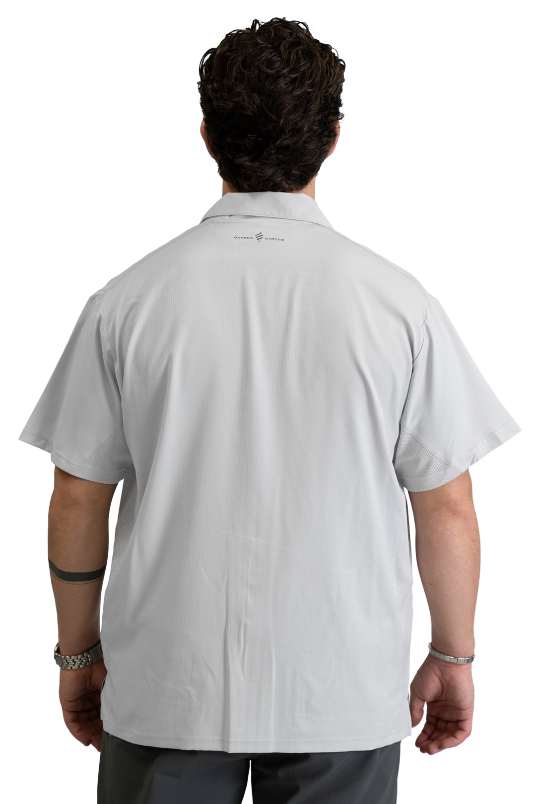 The Barber Jacket in Cool Gray, back view with the Barber Strong logo below the collar