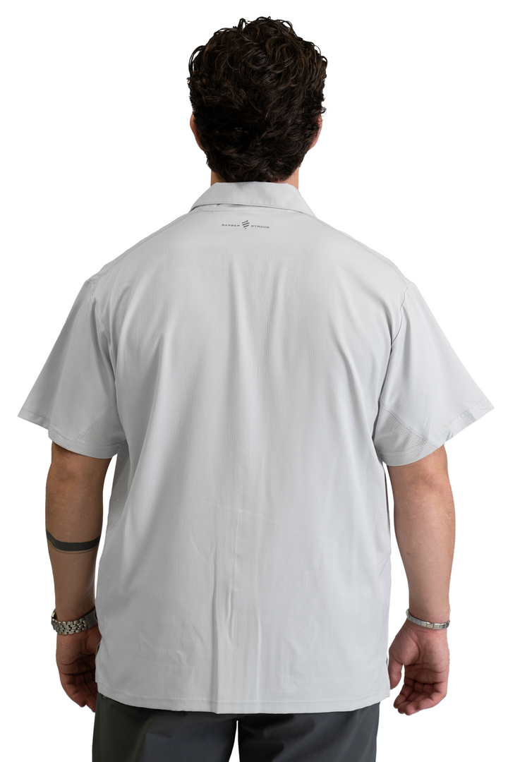 The Barber Jacket in Cool Gray, back view with the Barber Strong logo below the collar